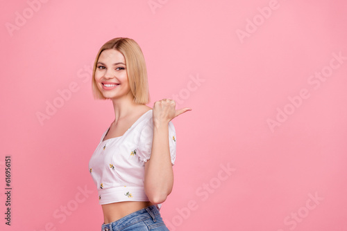 Portrait of pretty young lady showing empty space new clothes collection sale prices wear white crop shirt isolated pink color background