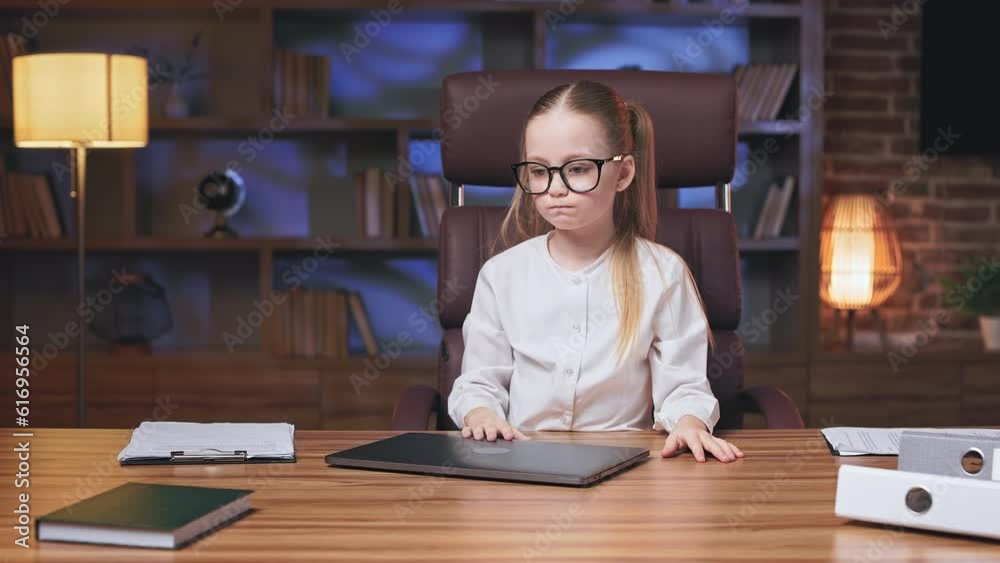 Little executive closing laptop and being annoyed because of gadget's bad work and low internet connection. Irritated kid shouting at computer and leaning on elbows with boring face expression. Little executive closing laptop and being annoyed because of gadget's bad work and low internet connection. Irritated kid shouting at computer and leaning on elbows with boring face expression.