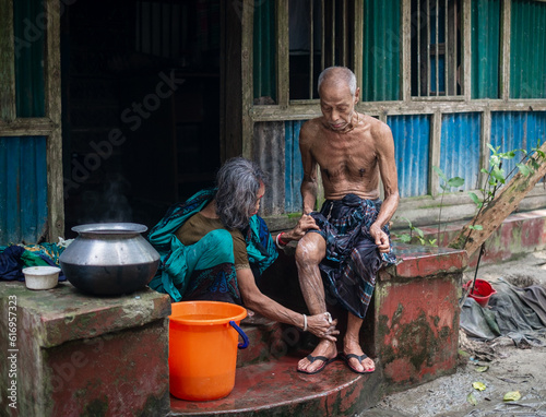 South asian elderly woman is bathing her diseased husband with care , family love concepts, happy couple 