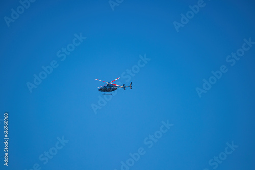 Fototapeta Naklejka Na Ścianę i Meble -  Blue helicopter flying in clear sky