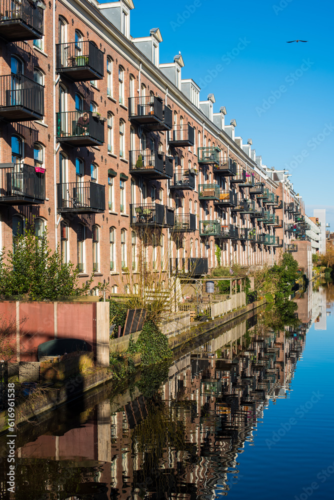 View of the street with canal houses and its reflection