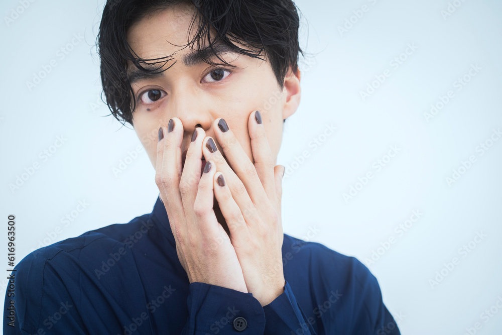 青いシャツを着た若いアジア人男性のビューティーポートレート/両手で顔を隠している 青いシャツを着た若いアジア人男性のビューティーポートレート/両手で顔を隠している