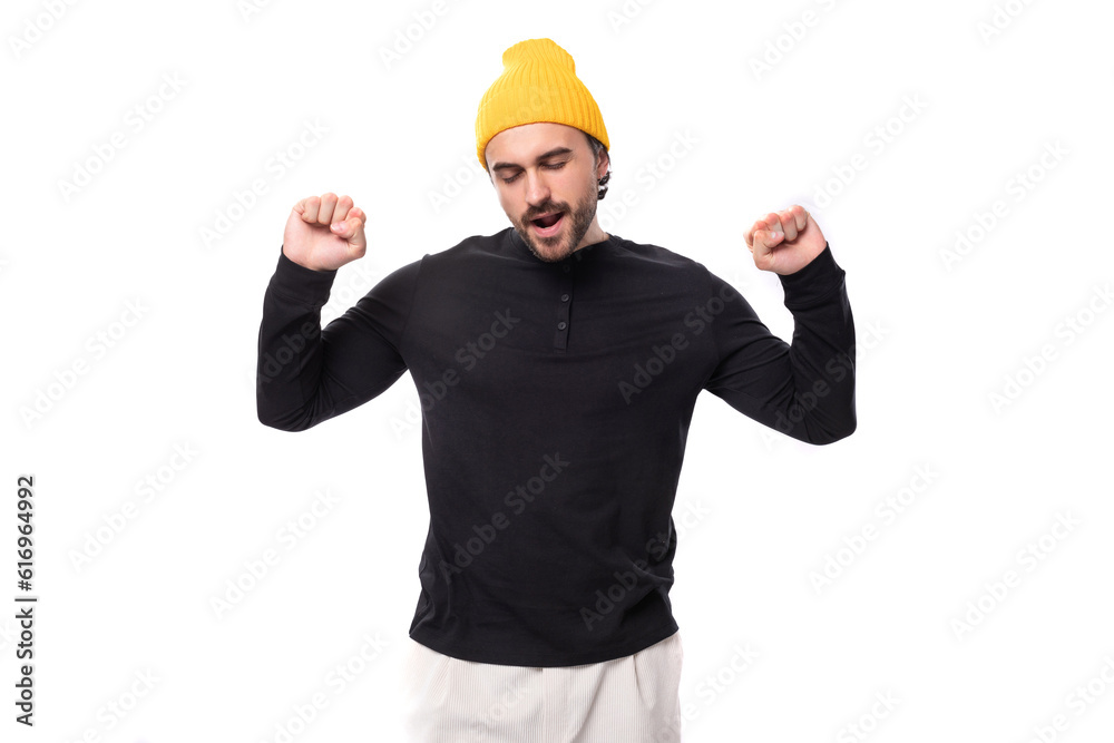 young stylish brunette European brutal man in a black sweatshirt rejoices young stylish brunette European brutal man in a black sweatshirt rejoices