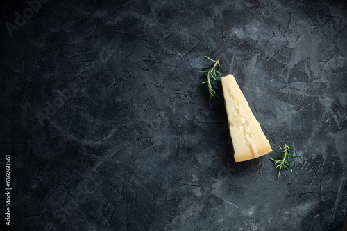 Hard cheese on black background. Parmesan. Top view. Free space for your text.