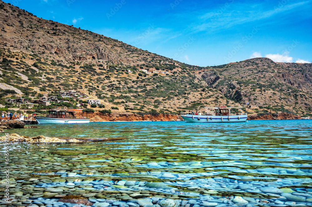Fototapeta premium The sparkling azure waters merge seamlessly with the clear blue sky, creating a harmonious and captivating scene. Solitary boat gracefully adorning the horizon.