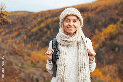 Middle Aged Woman with backpack walking in the autumn forest trip photo