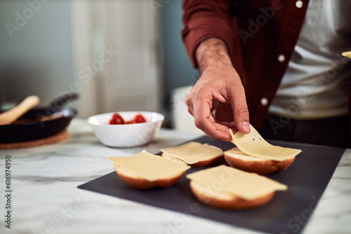 A close-up of a delicious sandwich with cheese is in progress in the kitchen.