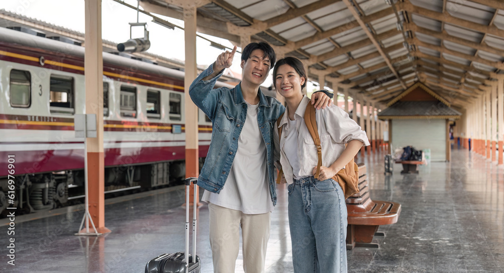 Asian couple travelers, backpack travelers, together at train station platform. tourism activity or railroad trip traveling concept Asian couple travelers, backpack travelers, together at train station platform. tourism activity or railroad trip traveling concept