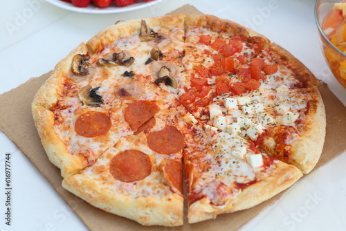 Pizza with mushrooms, sausage and olives on a wooden background