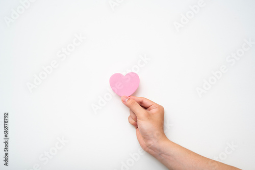 paper pink heart on adult hand on white background   valentine day love   happy  holiday  romantic  world heart day  world health day  praying concept