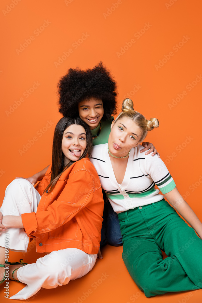 Φωτογραφία Positive and multiethnic teenage girlfriends in stylish casual outfits sticking