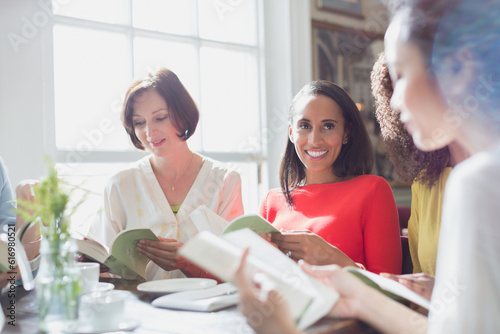Women friends discussing book club book at restaurant table photo