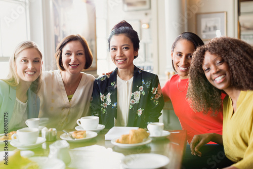 Fotografie Portrait smiling women friends drinking coffee at restaurant table