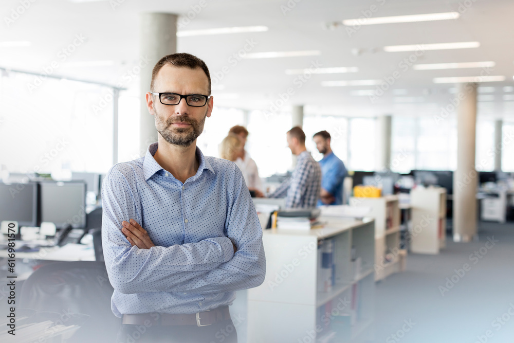 Portrait serious businessman with arms crossed in office Portrait serious businessman with arms crossed in office