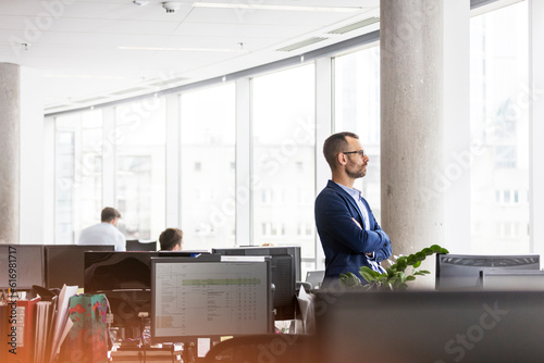 Pensive businessman looking out office window photo