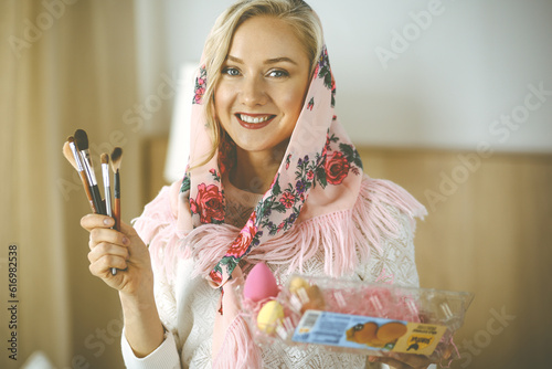 Smiling caucasian woman holding a basket with colorful Easter eggs