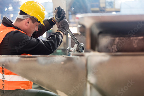Photos Steel worker using large wrench in factory