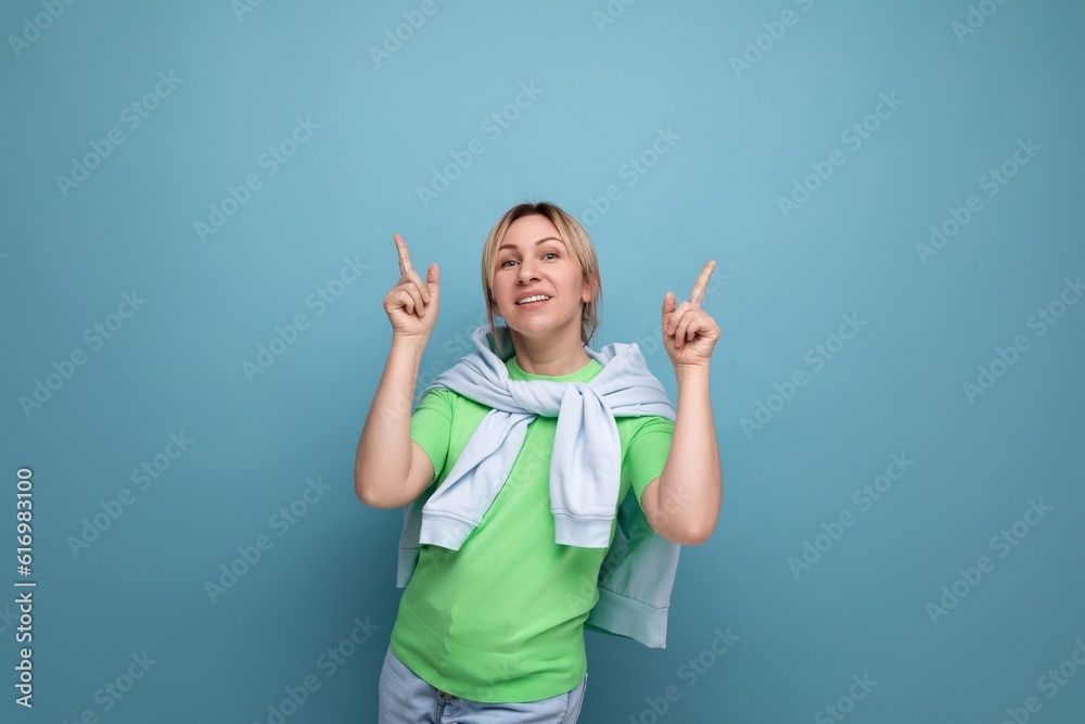 horizontal photo of a blond positive bright girl in a casual outfit on a blue background with copy space horizontal photo of a blond positive bright girl in a casual outfit on a blue background with copy space