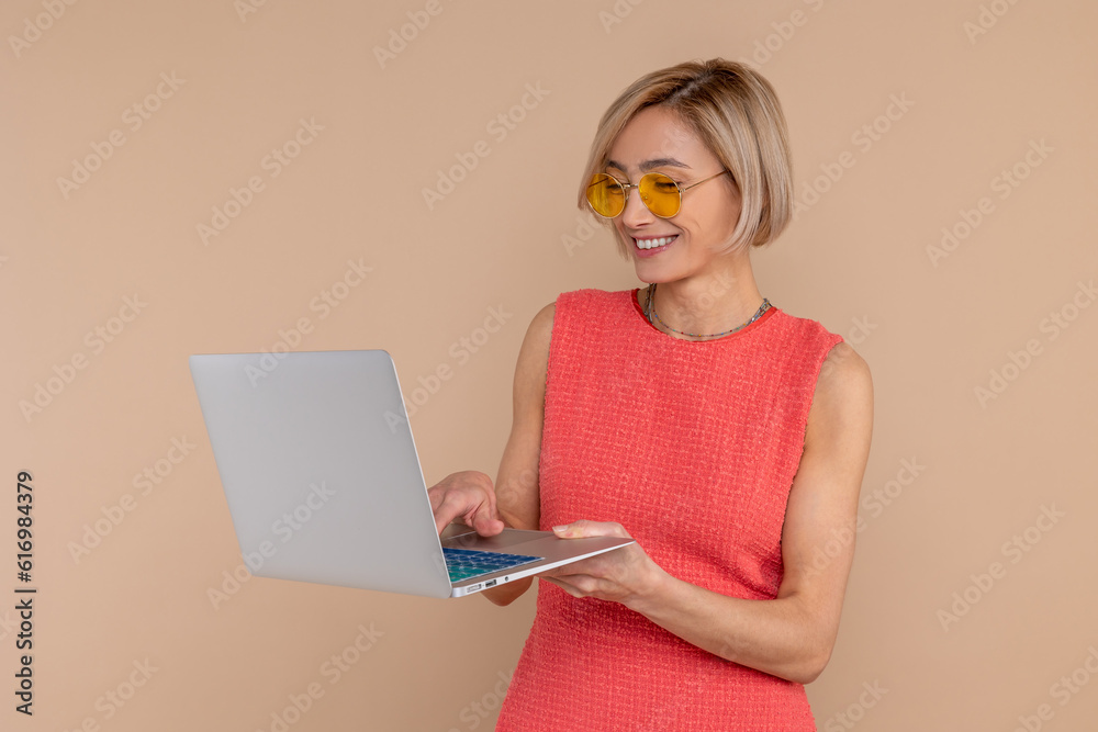 Remote work. Beautiful woman in dress and sunglasses working on portable computer Remote work. Beautiful woman in dress and sunglasses working on portable computer
