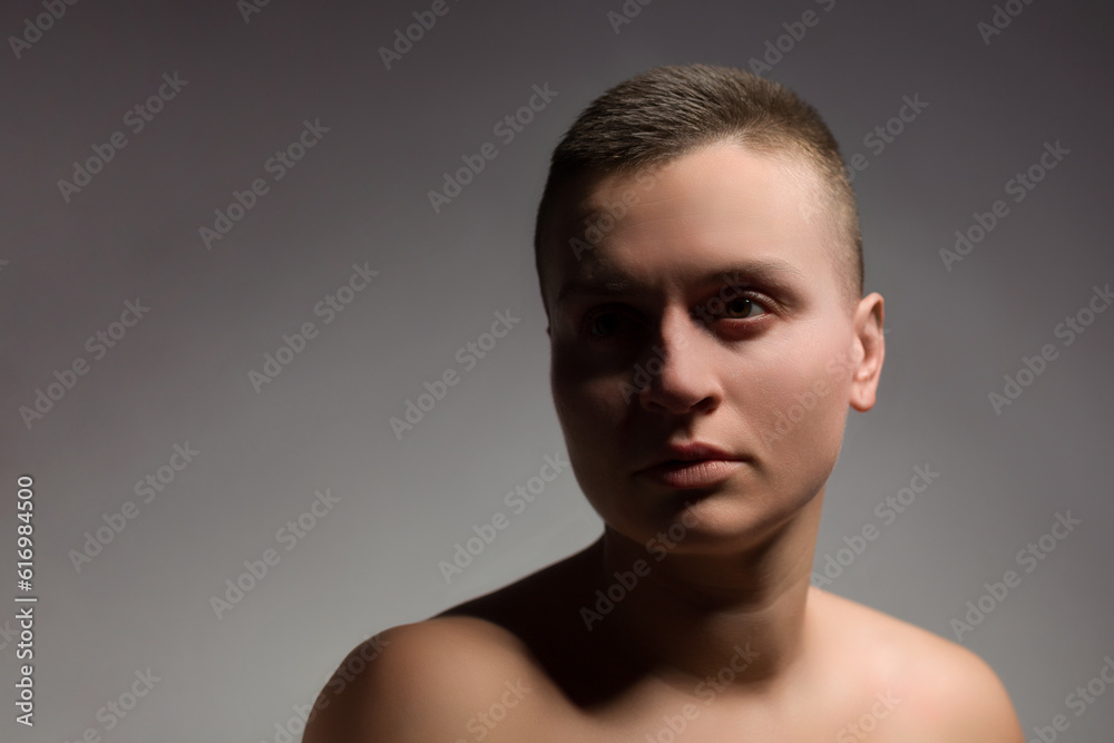 portrait of young woman with short hair and bare shoulder on grey bakground portrait of young woman with short hair and bare shoulder on grey bakground