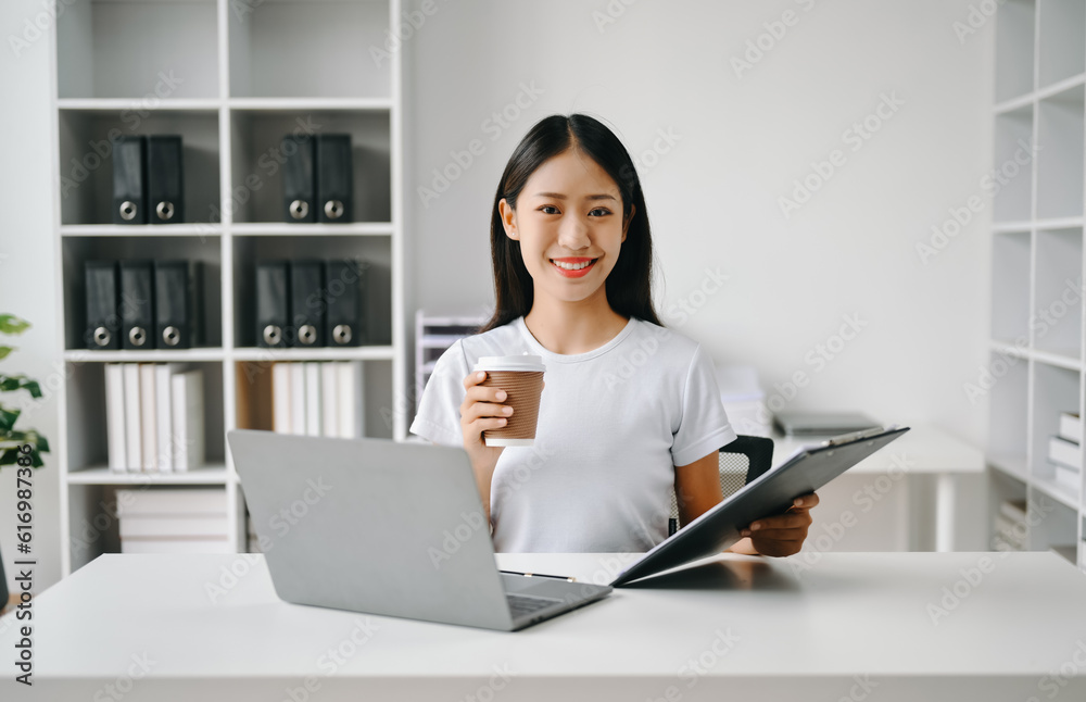 Successful Asian Businesswoman Analyzing Finance on Tablet and Laptop at Office Desk tax, report, accounting, statistics, and analytical research concept. Successful Asian Businesswoman Analyzing Finance on Tablet and Laptop at Office Desk tax, report, accounting, statistics, and analytical research concept.