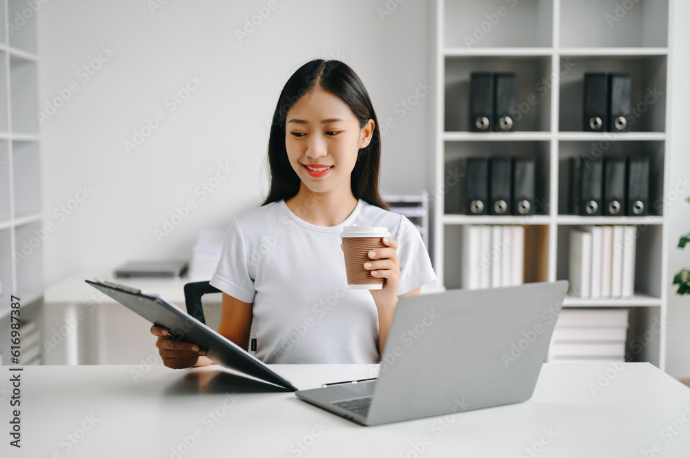 Successful Asian Businesswoman Analyzing Finance on Tablet and Laptop at Office Desk tax, report, accounting, statistics, and analytical research concept. Successful Asian Businesswoman Analyzing Finance on Tablet and Laptop at Office Desk tax, report, accounting, statistics, and analytical research concept.