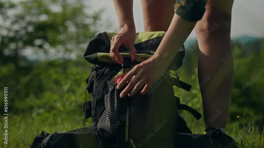 Walking on foot, girl traveler Puts a first aid bag in a tourist backpack In the mountains. working mother In harmony with nature, she masters new techniques for testing herself in the wild, sports

