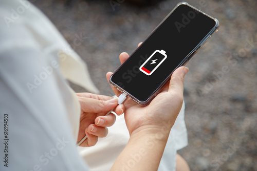 Close up a woman hands charging her mobile phone with charging icon