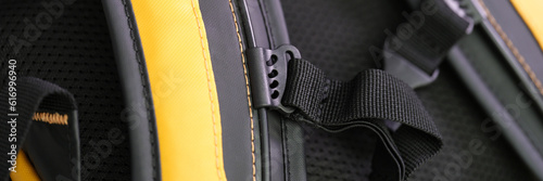 Shoulder straps in yellow and black backpack for comfortable carrying on back closeup. Orthopedic backpacks concept photo