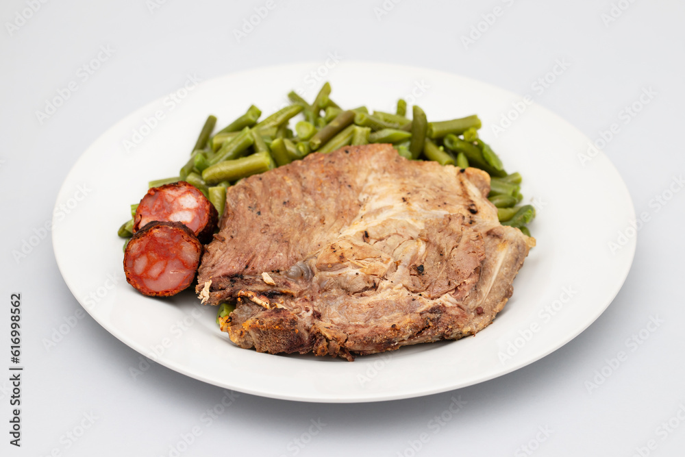 Green beans with meat and smoked sausages on plate Green beans with meat and smoked sausages on plate