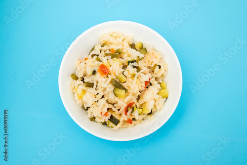 Cooked white rice mixed with colorful vegetables onion, green beans, tomato