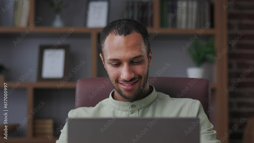 Young african american businessman working with laptop at office. Texting messages, browsing internet, studying online, remote working. Close up portrait of entrepreneur, manager, trader at workplace.
