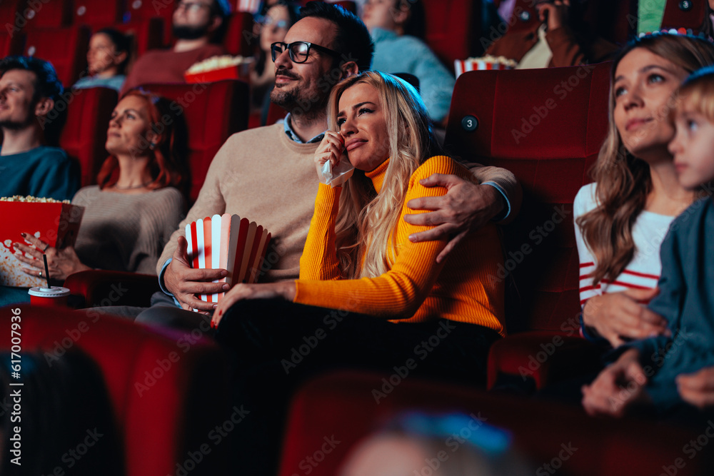 Couple watching sad movie in cinema.