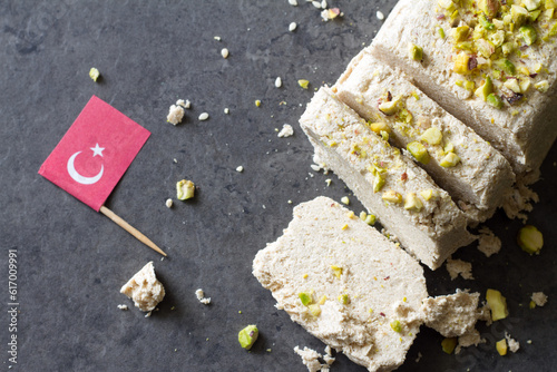 Sesame halva with pistachios on grey background, traditional turkish delicacy
