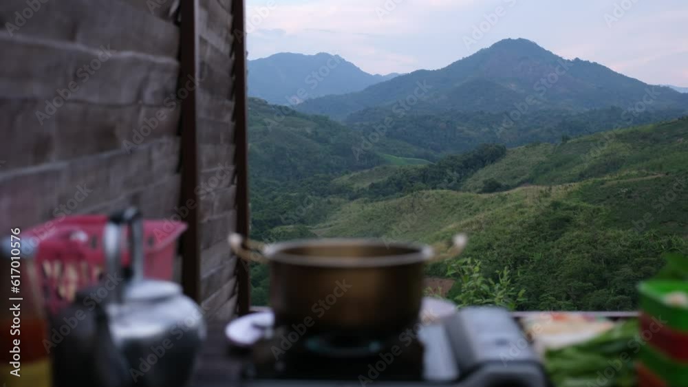 Blurred of Shabu Shabu Hot Pot on portable stove and food on the table with mountain views Blurred of Shabu Shabu Hot Pot on portable stove and food on the table with mountain views