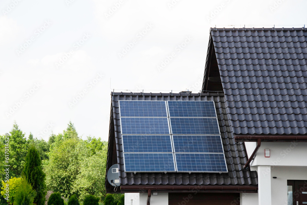 Naklejka premium Installing a Solar Cell on a Roof. Solar panels on roof. Historic farm house with modern solar panels on roof and wall. High quality photo