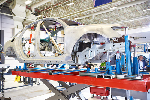 Metal car coachbuilder on lift in factory