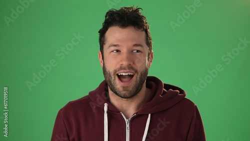 Fotografie Close up head shot portrait man applicant on green screen chroma key wave hand g