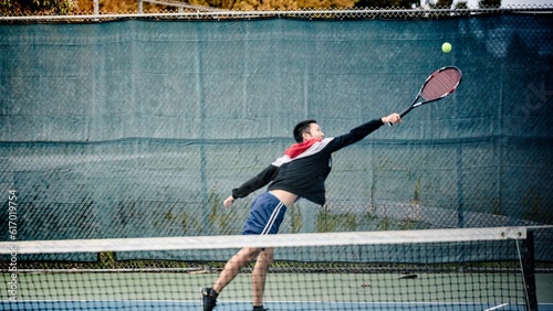 Man�reaching for tennis ball�on court photo