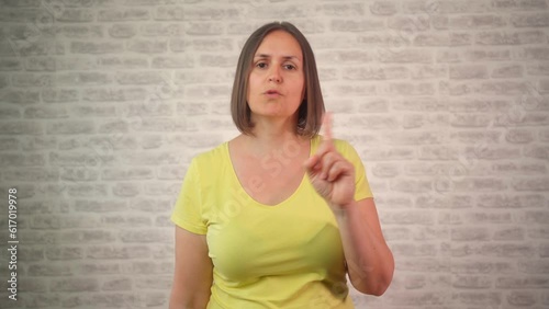 Woman says no with index finger on isolated background. Disapproval
