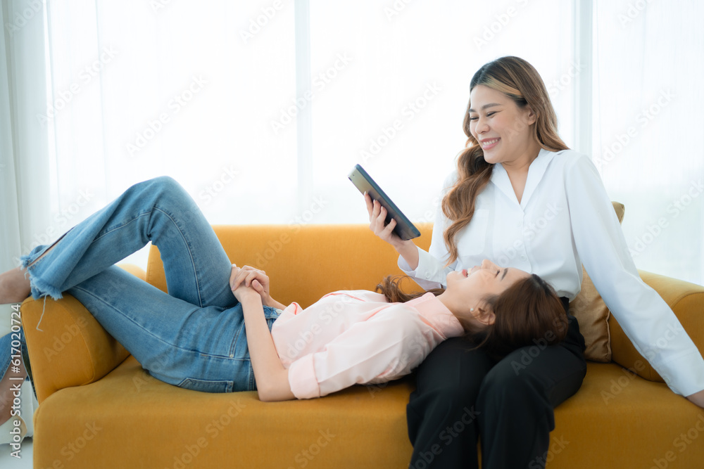LGBT couple sitting on sofa and using laptop computer at home. LGBT couple sitting on sofa and using laptop computer at home.