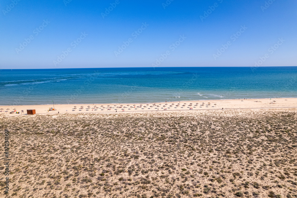 Aerial seascape view of Ilha deserta island beach, one of the barrier islands that protect the Ria Formosa natural park, in Algarve Tourism Destination Region, in Portugal south coast.