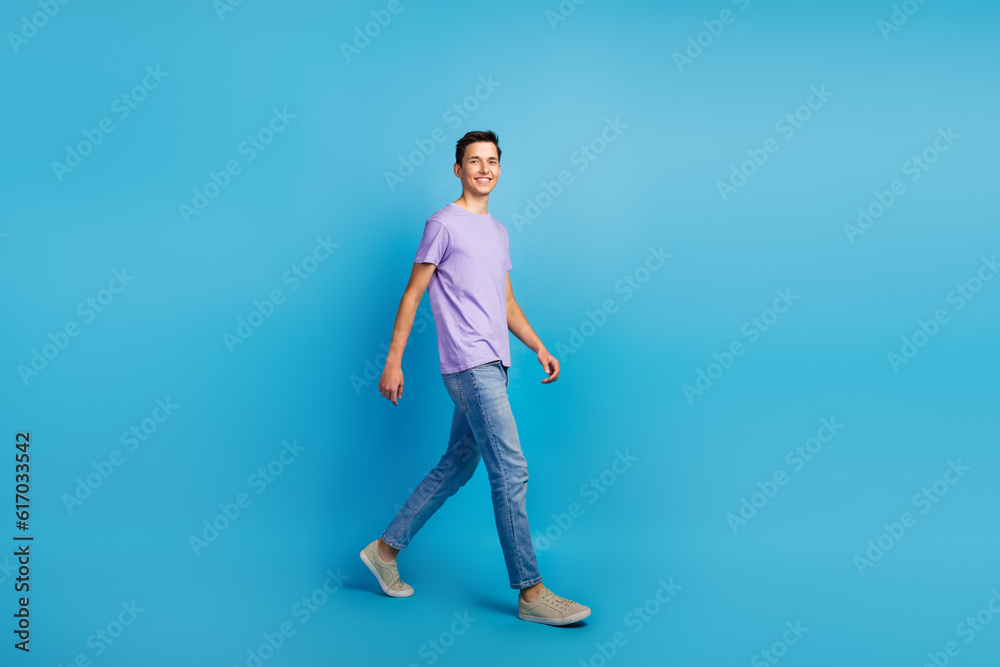 Photo of positive cheerful man enjoy go walk wear casual style clothes isolated over blue color background