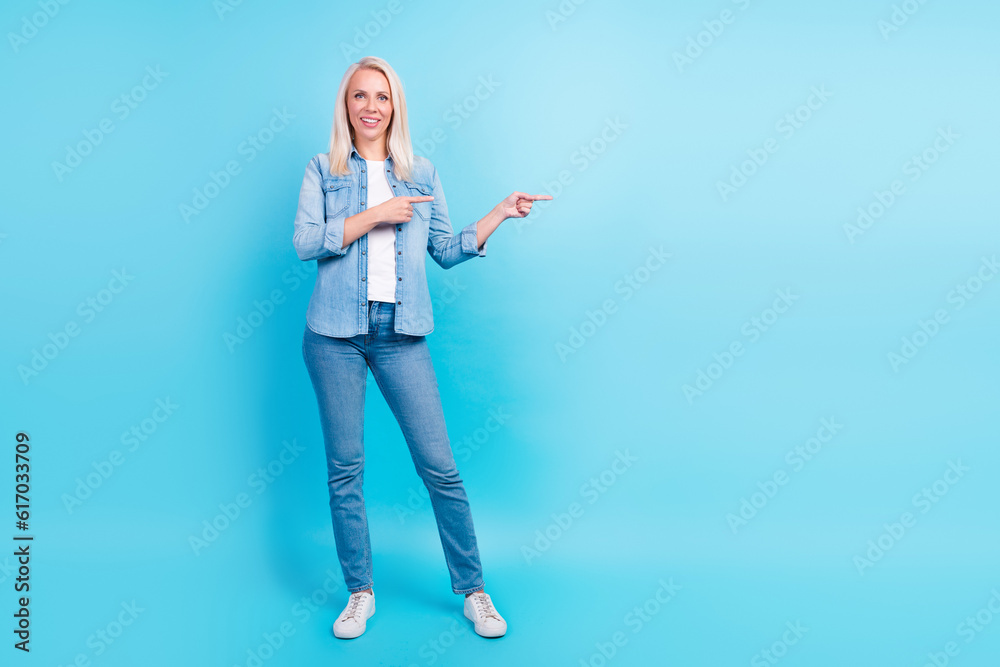 Full length photo of tall slim business woman pointing fingers empty space promo advert isolated blue color background Full length photo of tall slim business woman pointing fingers empty space promo advert isolated blue color background