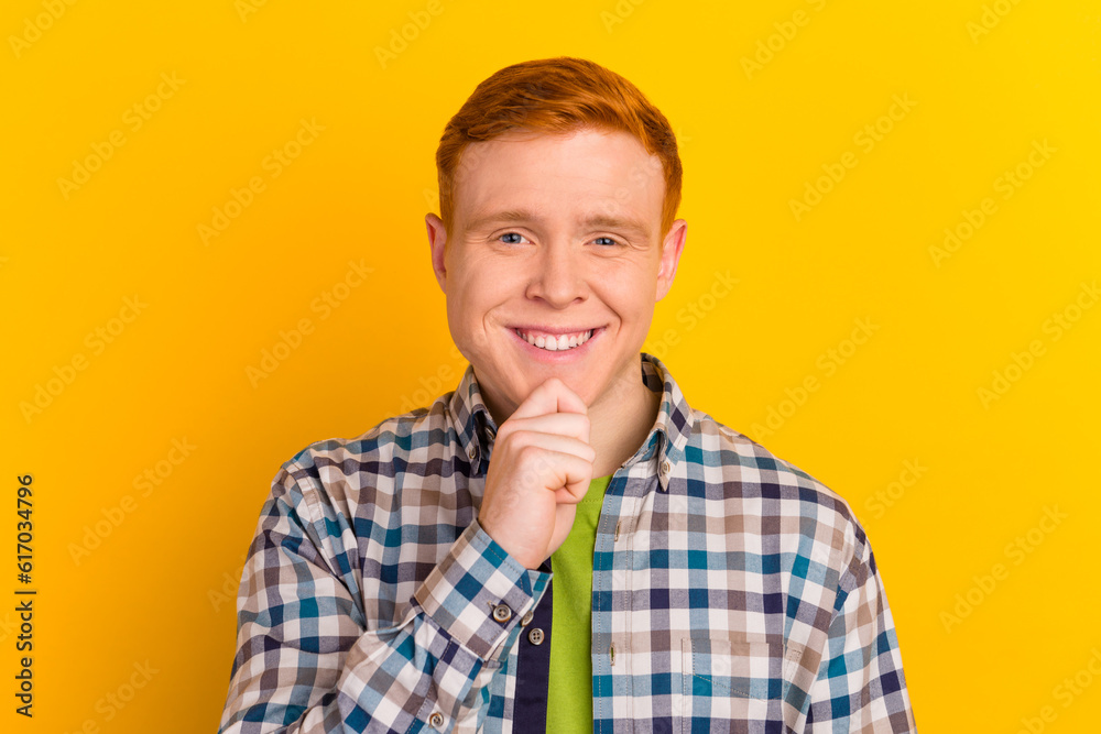 Portrait of the young thinking man looks with hand near face isolated on shine color background