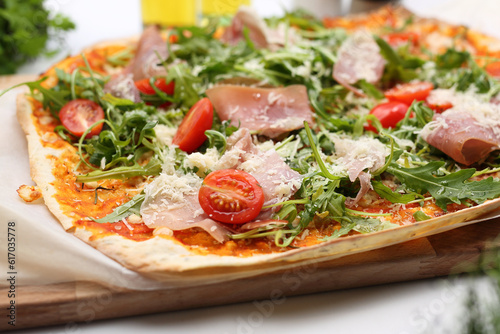 Pizza with cherry tomato, Italian ham, cheese, tomato sauce and arugula. Pizza prosciutto, Italian cuisine, close-up.