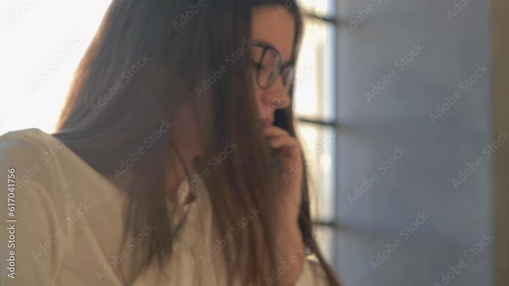 Businesswoman answering phone and writing on notepad on table in office Businesswoman answering phone and writing on notepad on table in office