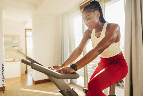 Fit African woman keeps up healthy lifestyle with exercise bike