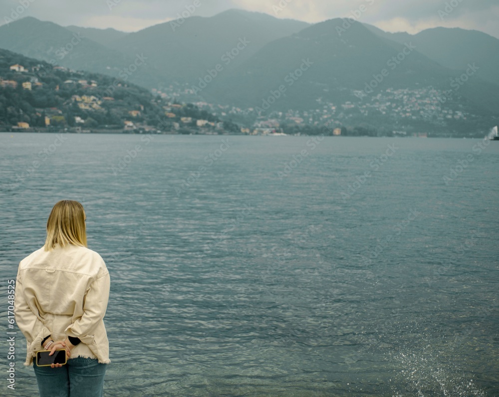 Photo session of a girl on the background of a lake overlooking the mountains.  Italy, Como, May 2023.