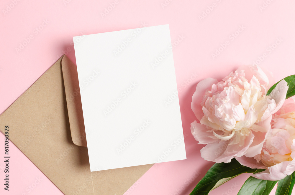 Blank invitation or greeting card mockup with envelope and pink peony flowers, top view, copy space Blank invitation or greeting card mockup with envelope and pink peony flowers, top view, copy space